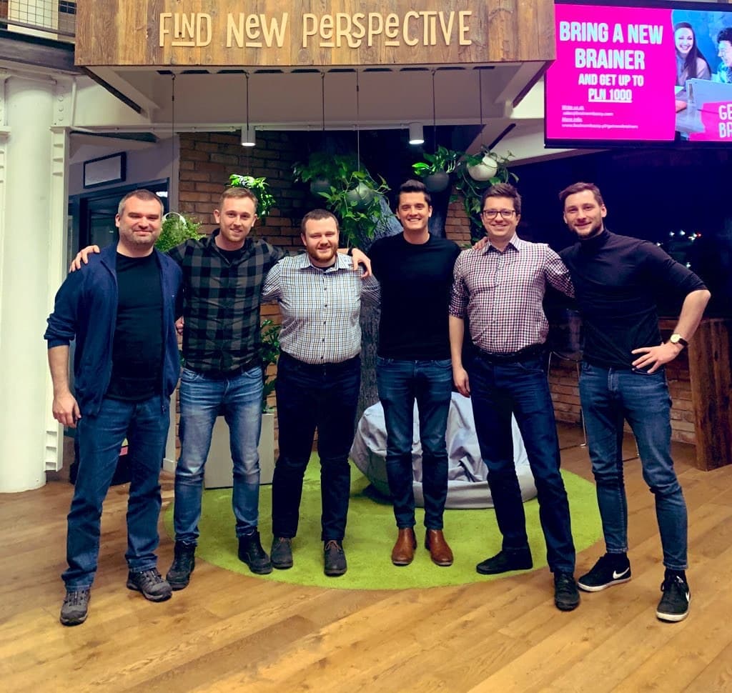 Nik with his team under a Find New Perspective sign after his first exit.
